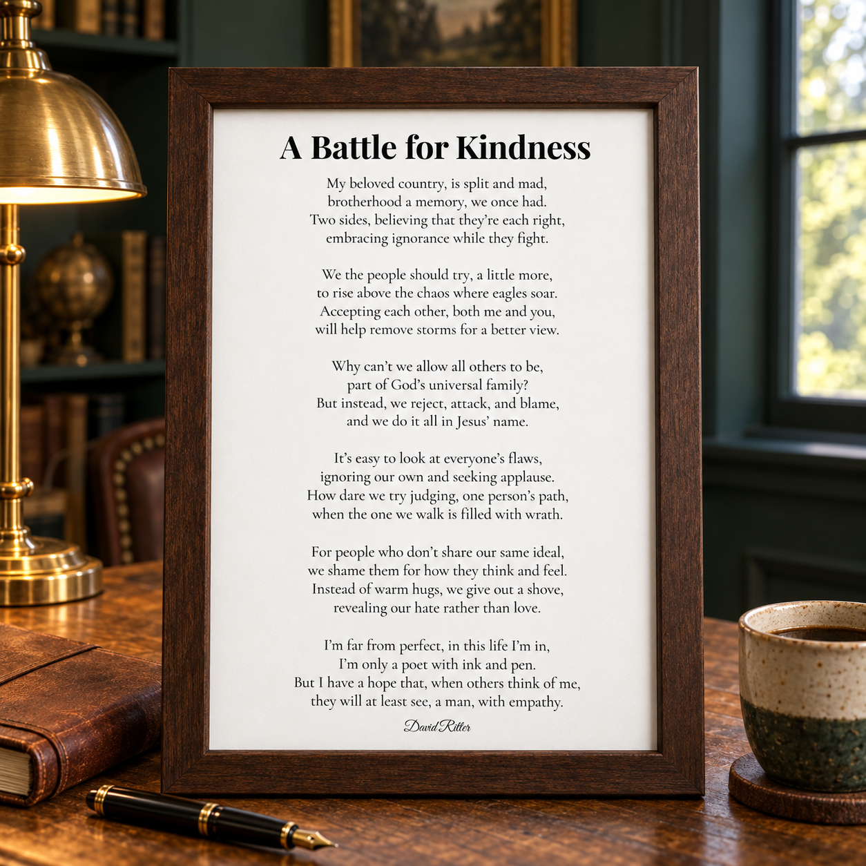 A Battle for Kindness poem by David Ritter shown in a dark wood frame on a desk beside a lamp and coffee cup.